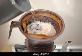 Coador de café de papel, com café em pó sendo molhado com água quente,  suporte de plástico e bule de alumínio Stock Photo - Alamy